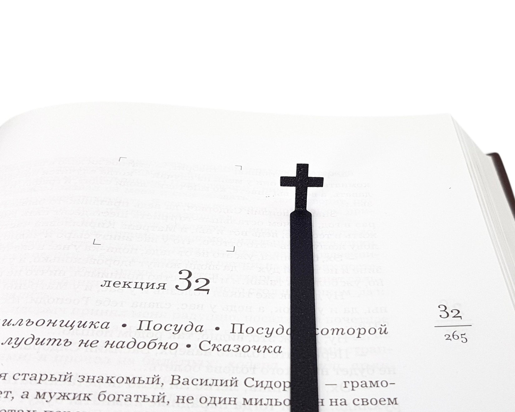 Straight Cross metal bookmark marking a page in an open book