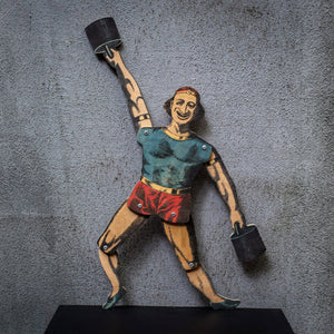 articulated plywood strongman puppet lifting weights, vintage style with movable joints