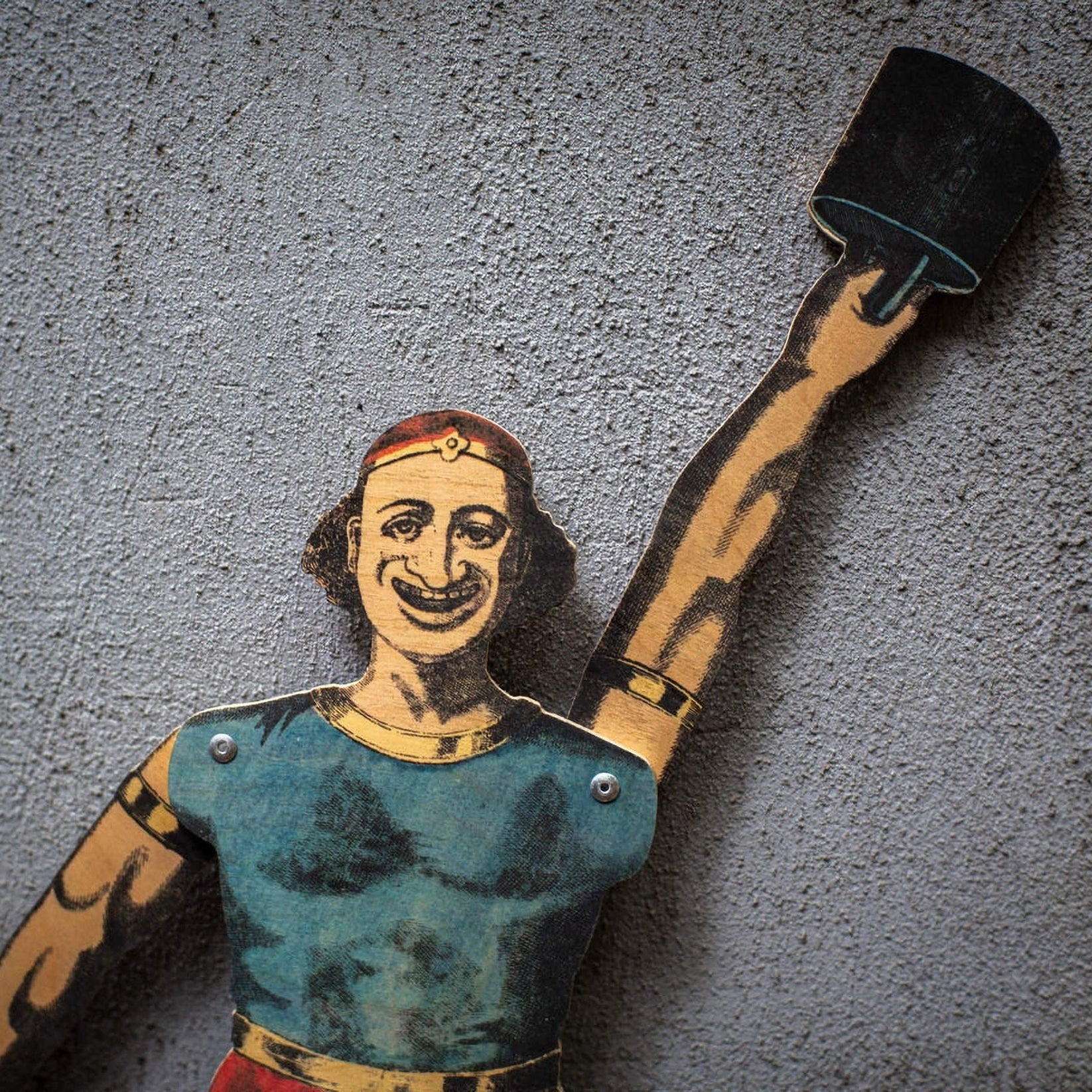 close up of plywood strongman puppet raising weight, vintage style articulated figure