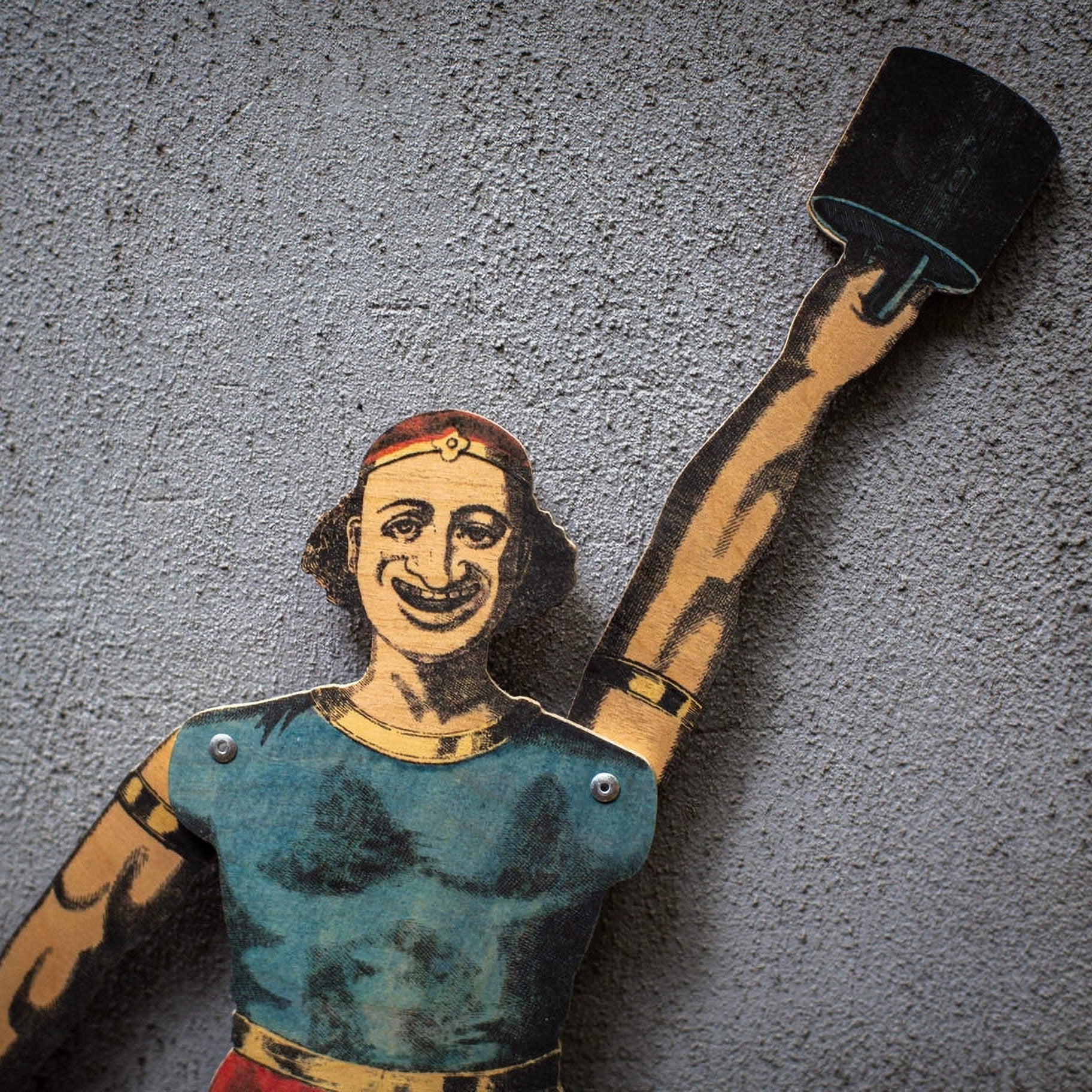 close up of plywood strongman puppet raising weight, vintage style articulated figure