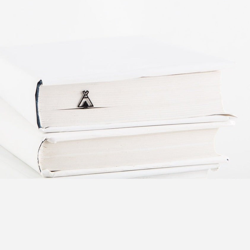 Teepee metal bookmark in a closed book, only its top showing above the pages