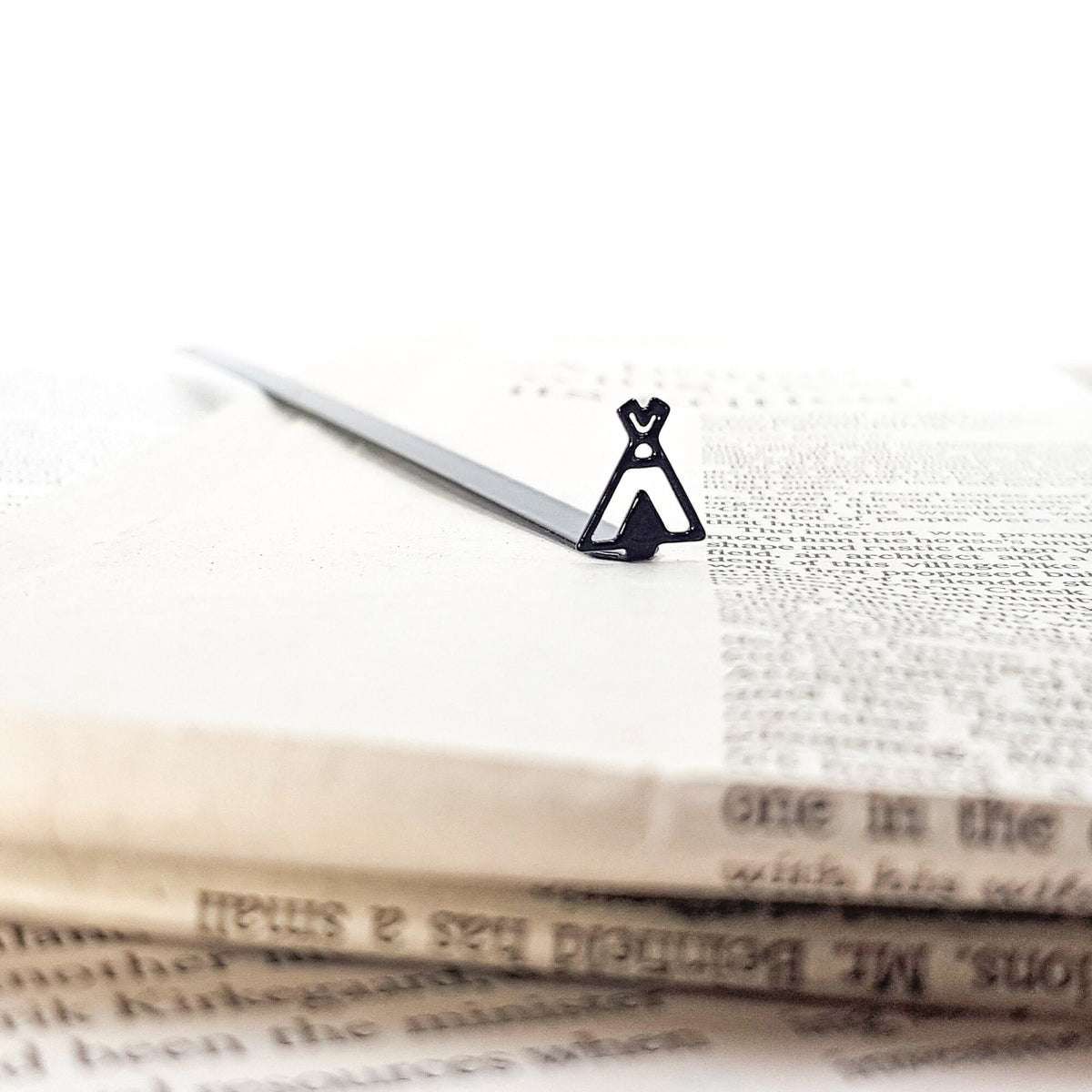 Teepee Tent metal bookmark marking a page in an open book
