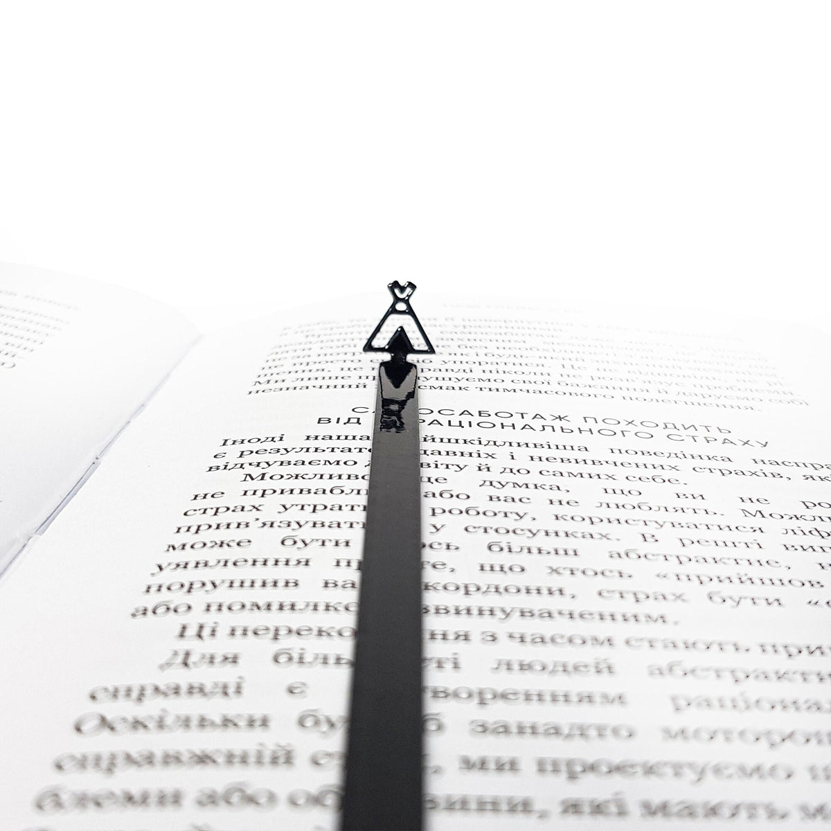 Teepee Tent metal bookmark lying across the pages of an open book