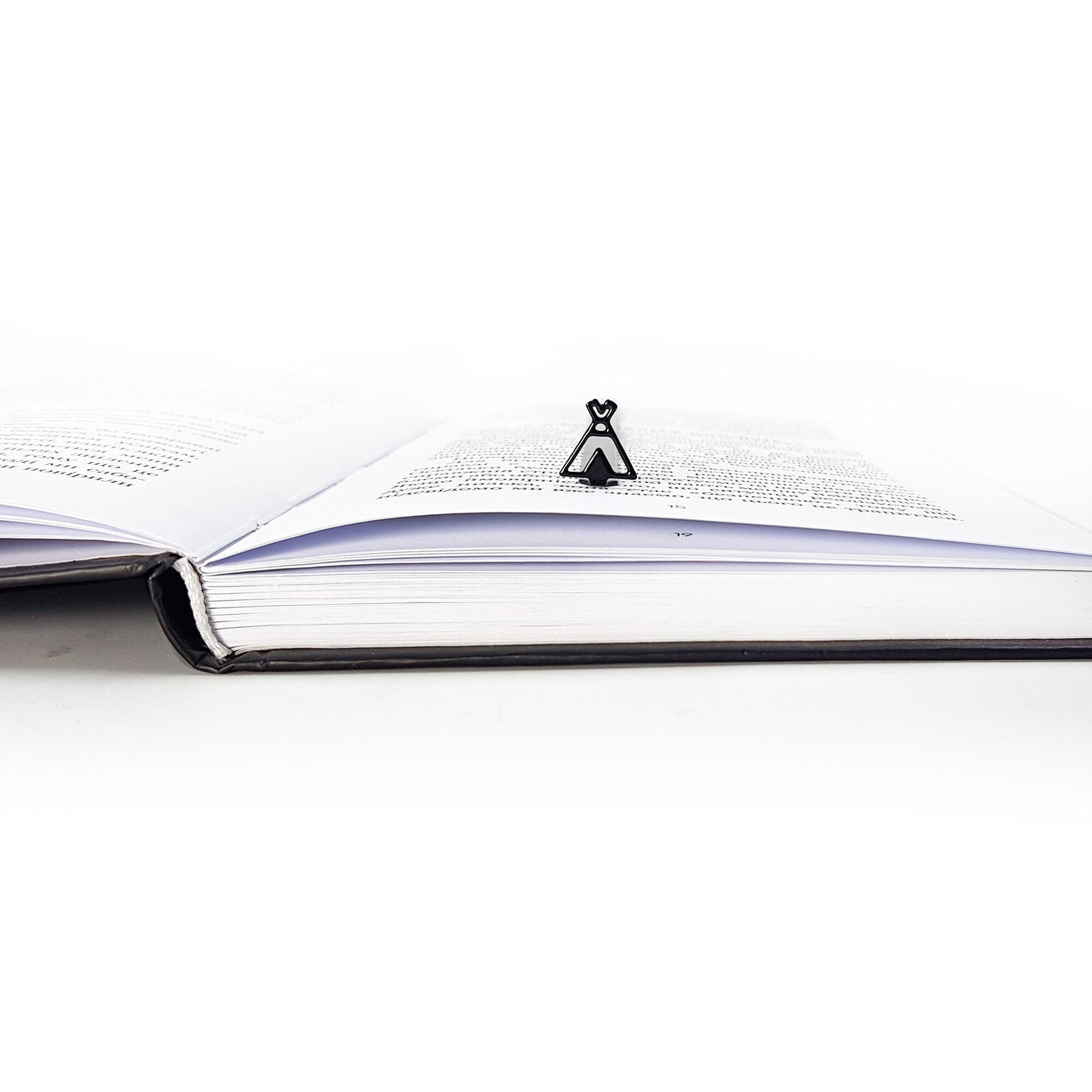 Teepee Tent metal bookmark set into the gutter of an open book