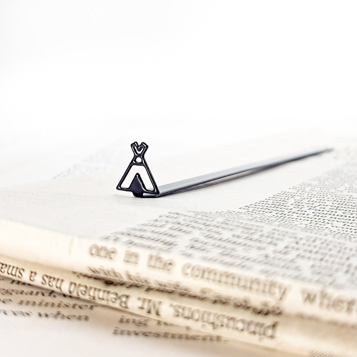 Teepee Tent metal bookmark resting on the pages of an open book