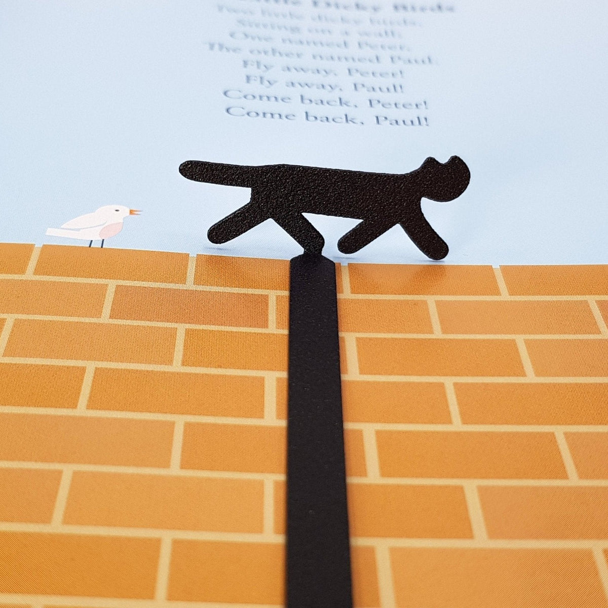 The Cat That Walked by Himself metal bookmark marking a page in an illustrated book