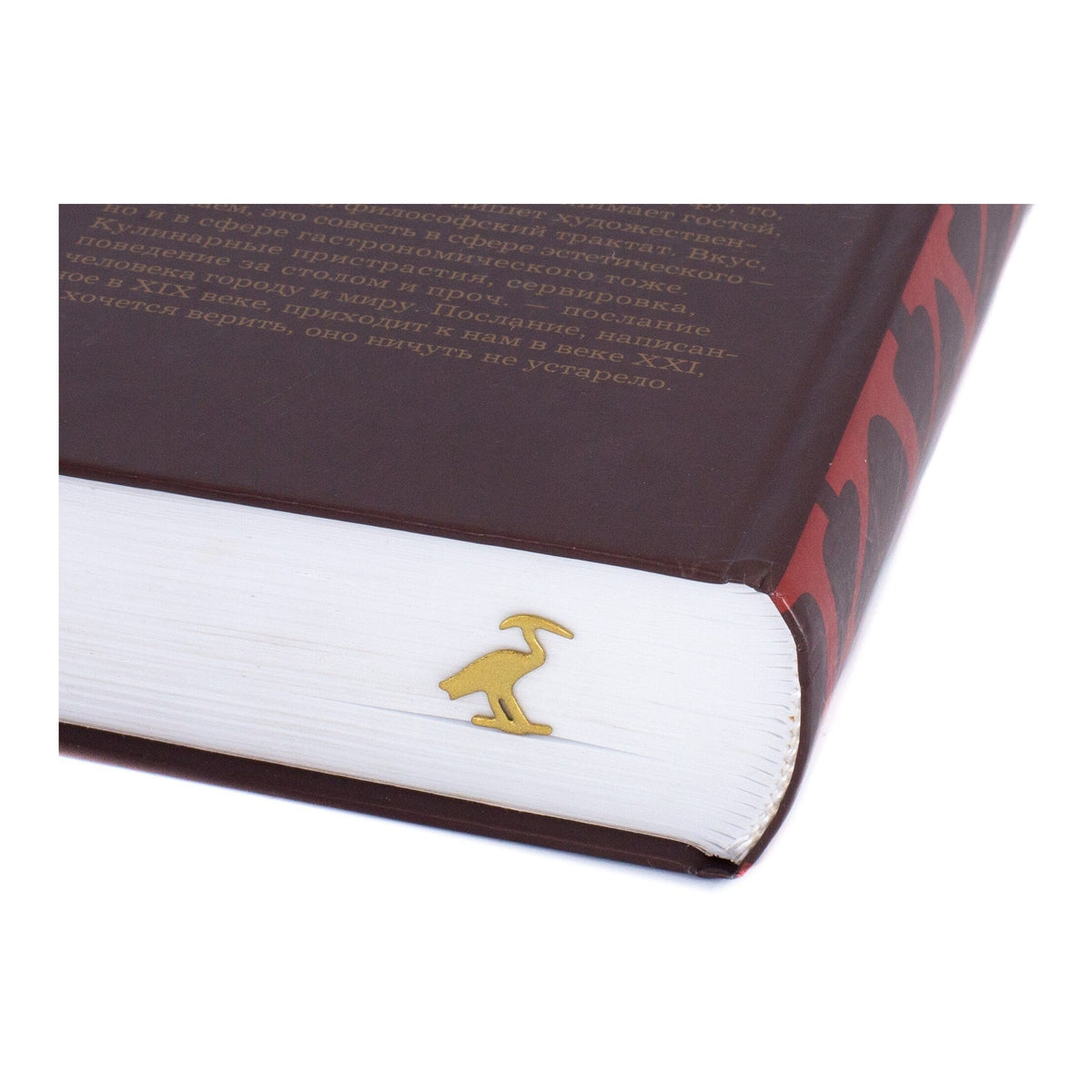 The Sacred Ibis metal bookmark in gold in a closed book, only its top showing above the pages