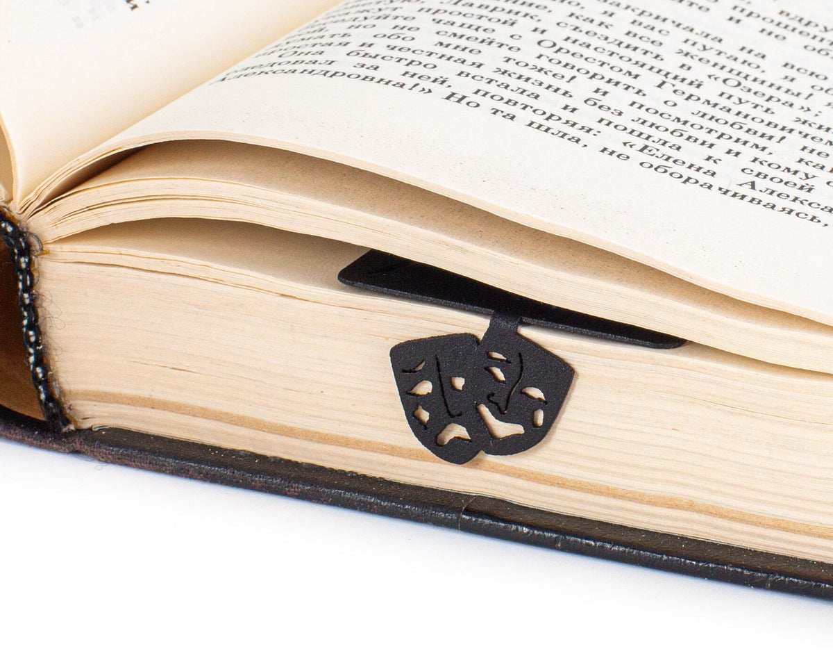 Theater metal bookmark lying across the pages of an open book