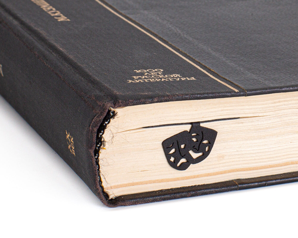 Theater metal bookmark in a closed book, only its top showing above the pages