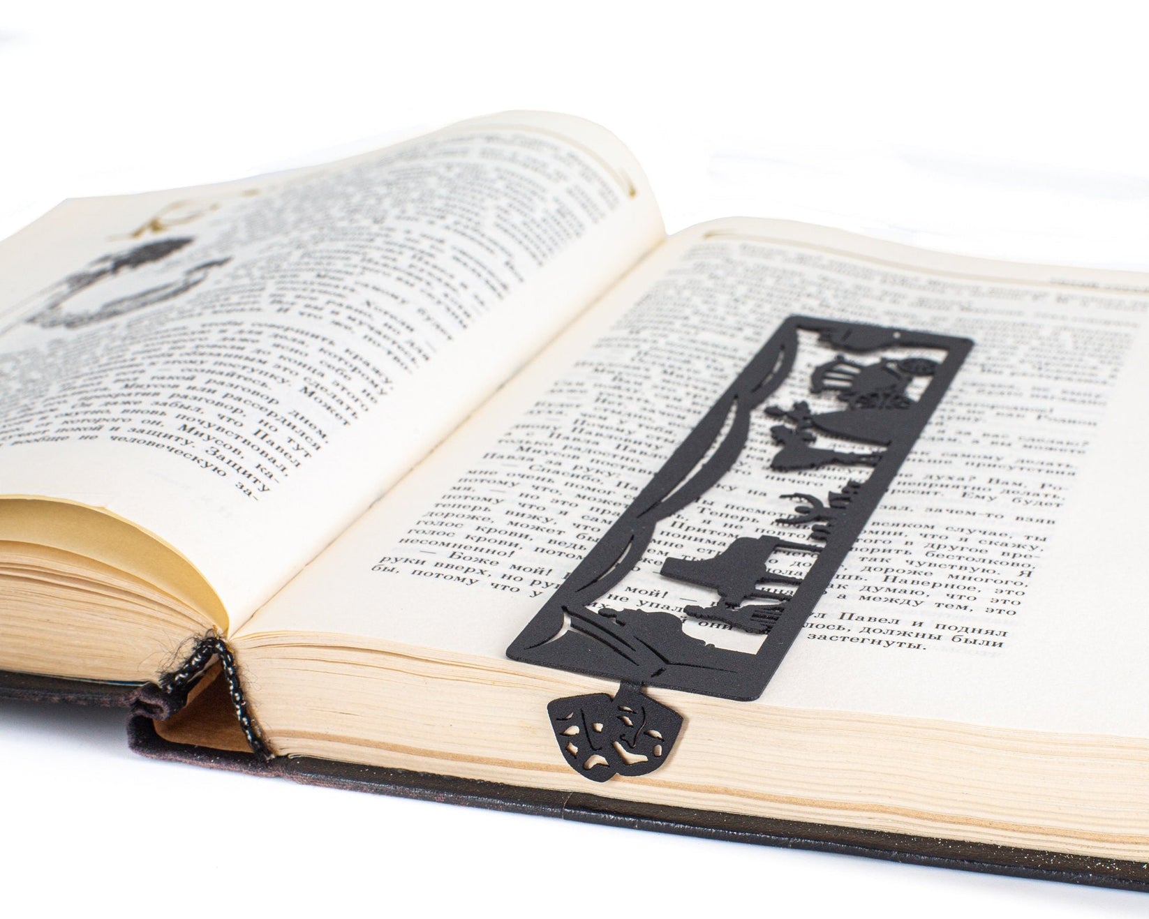 Theater metal bookmark marking a page in an open book