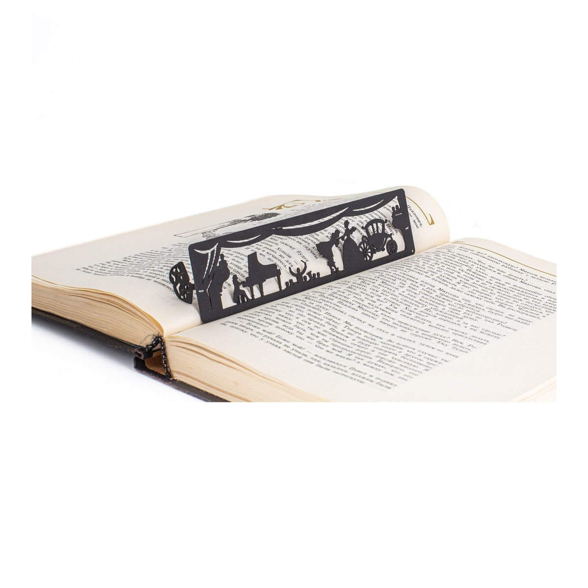Theater metal bookmark resting on the pages of an open book