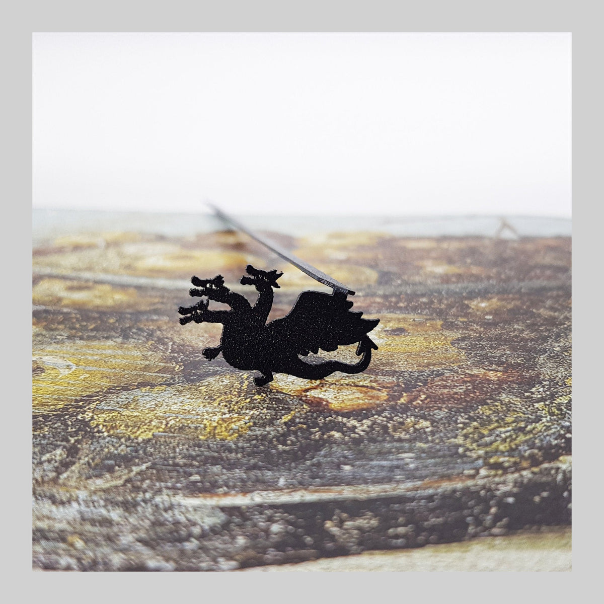 Three Headed Dragon metal bookmark on a coloured background