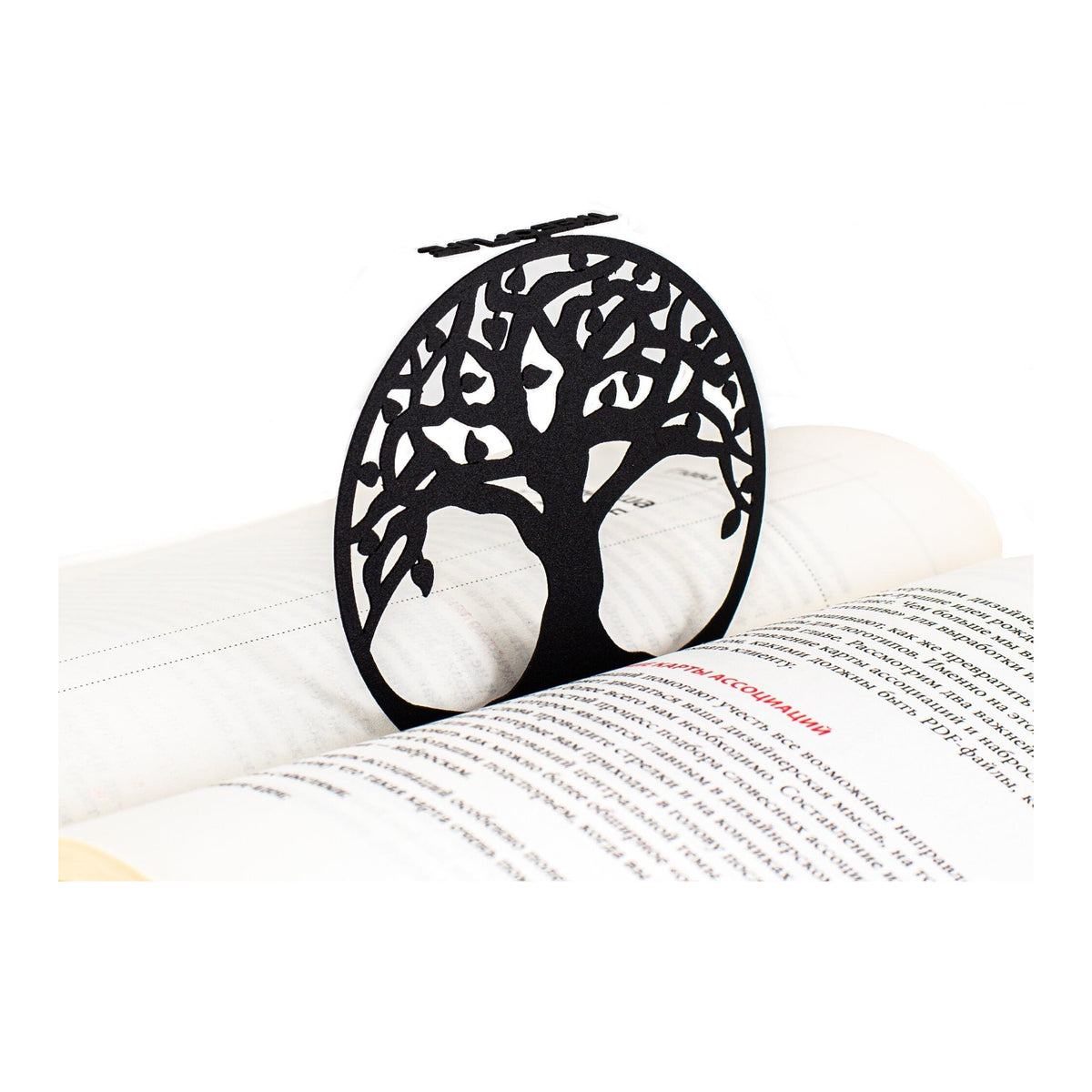 Tree of Life metal bookmark resting on the pages of an open book