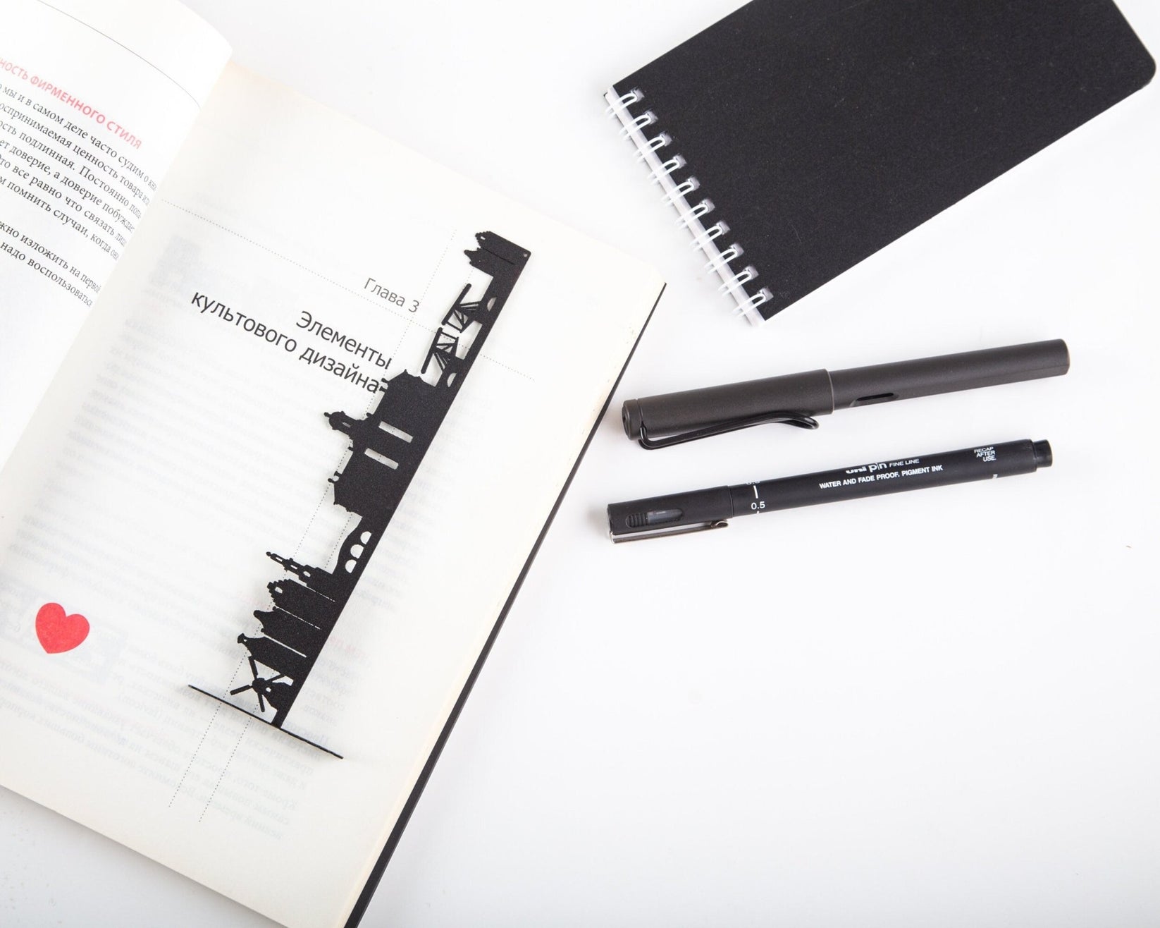 Trip Journal Amsterdam Cityscape metal bookmark tucked into a notebook, view 5