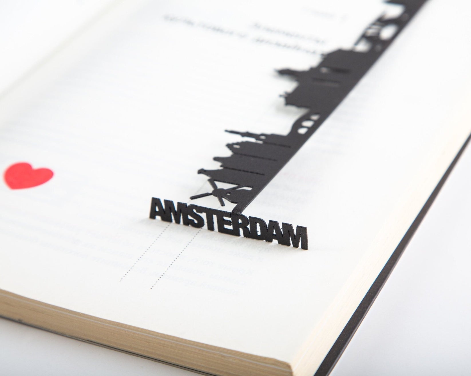 Trip Journal Amsterdam Cityscape metal bookmark marking a page in a notebook