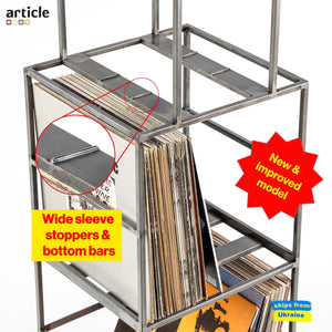 Detail view of upgraded vinyl record stand in raw steel finish, highlighting wide sleeve stoppers and bottom support bars with close-up inset. Features “New & improved model” badge.