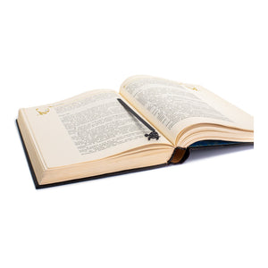 Turtle metal bookmark resting on the pages of an open book
