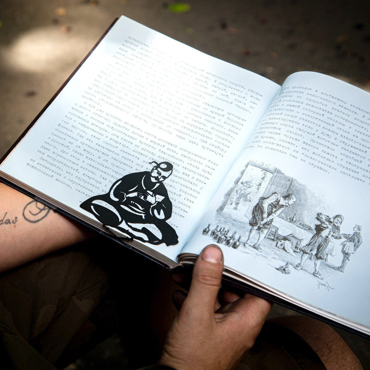 Ukrainian Kozak metal bookmark held in a hand above an open book