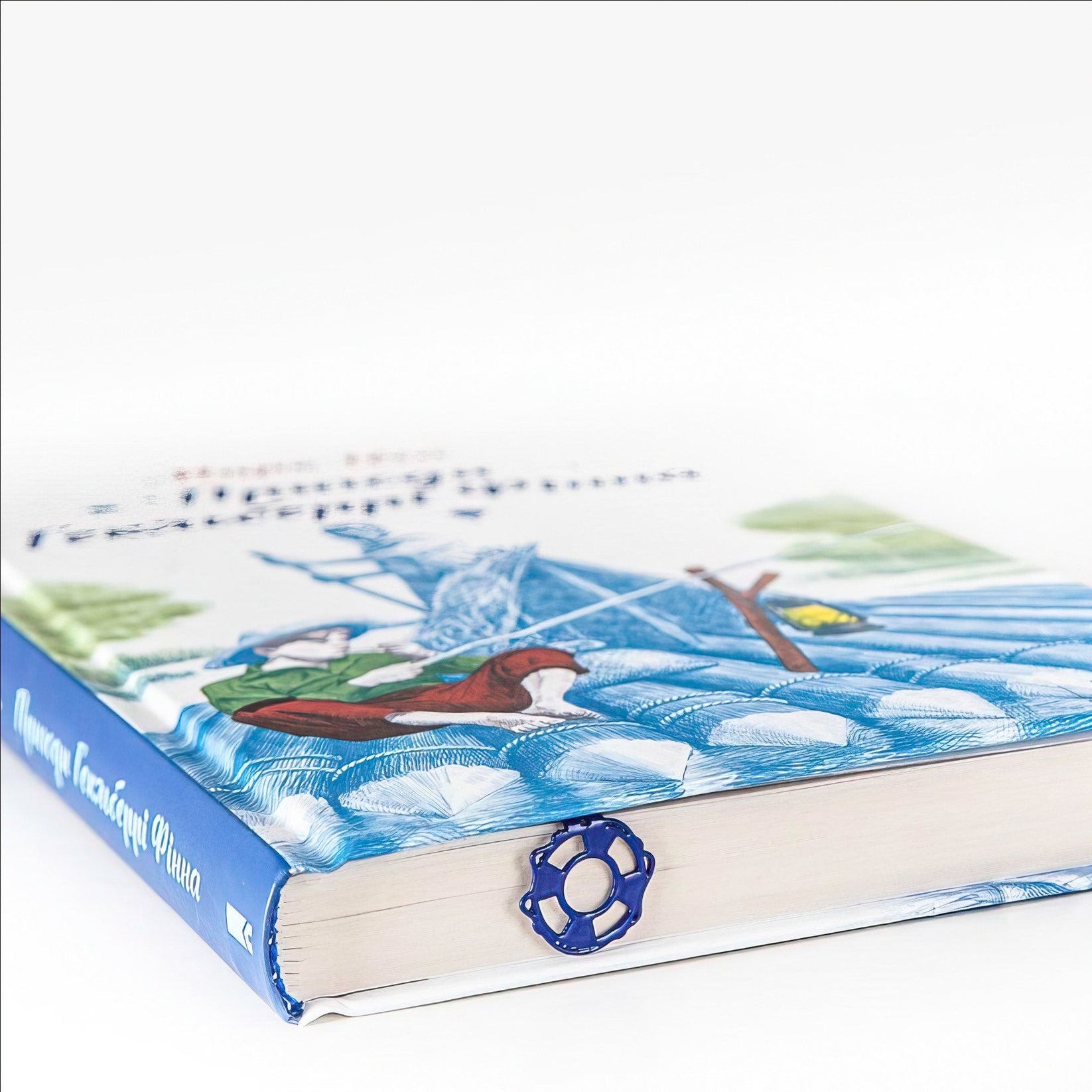 Diving Girl metal bookmark in blue on an illustrated page