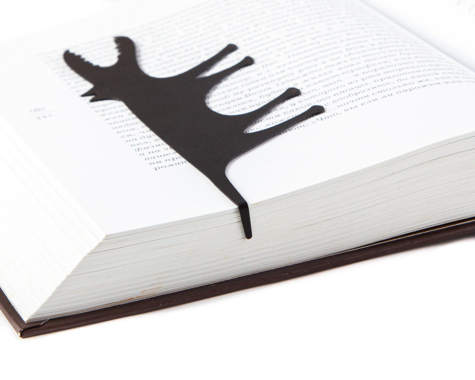 Hungry Wolf metal bookmark marking a page in an open book