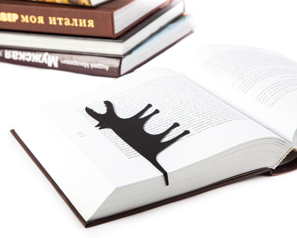 Hungry Wolf metal bookmark resting on the pages of an open book