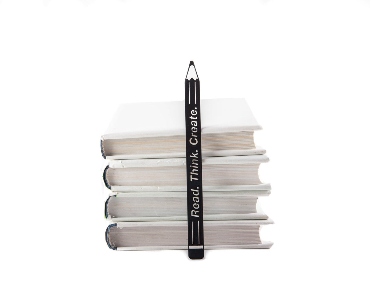 Pencil Read, Think, Create metal bookmark shown with a stack of books