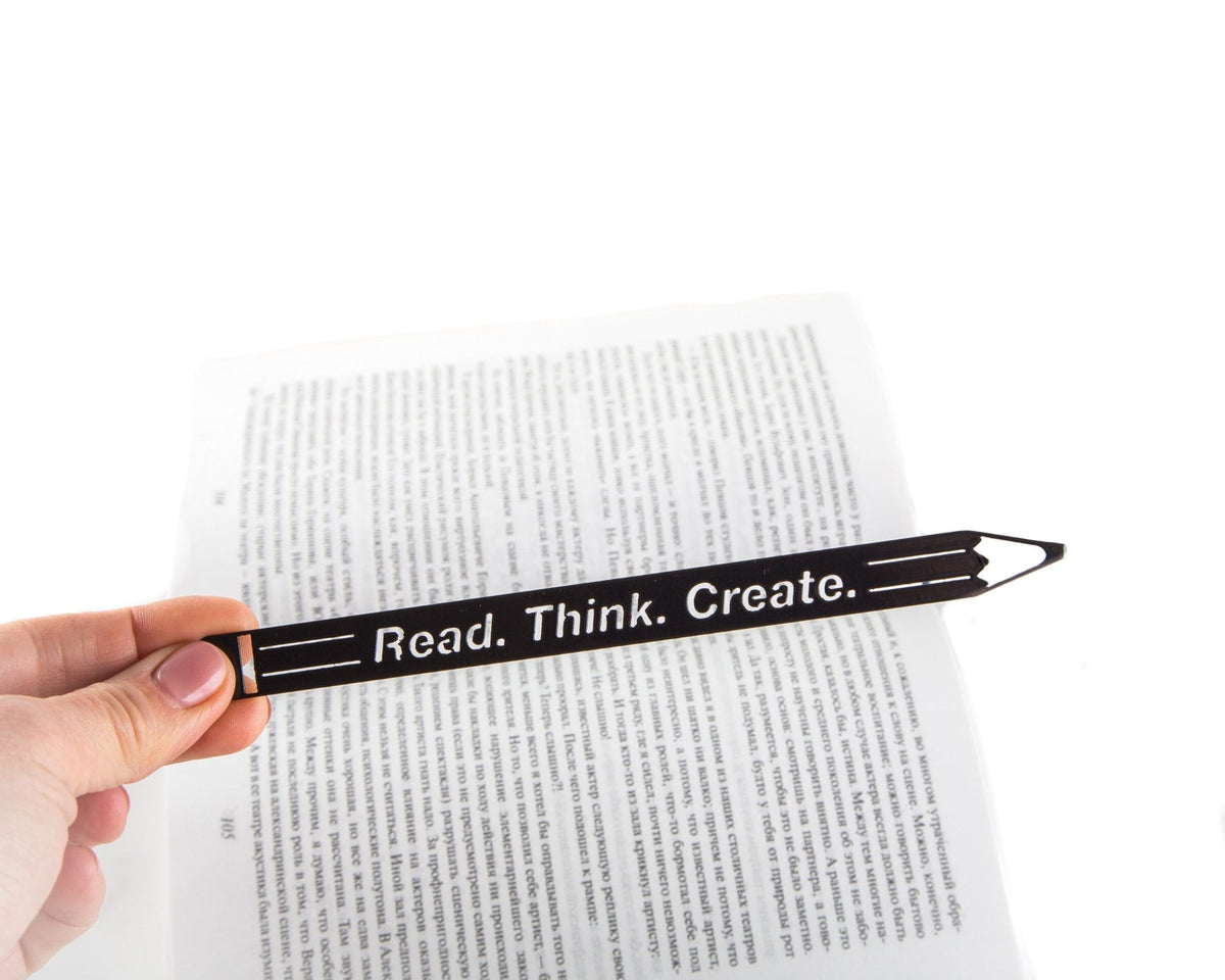 Pencil Read, Think, Create metal bookmark marking a page in an open book