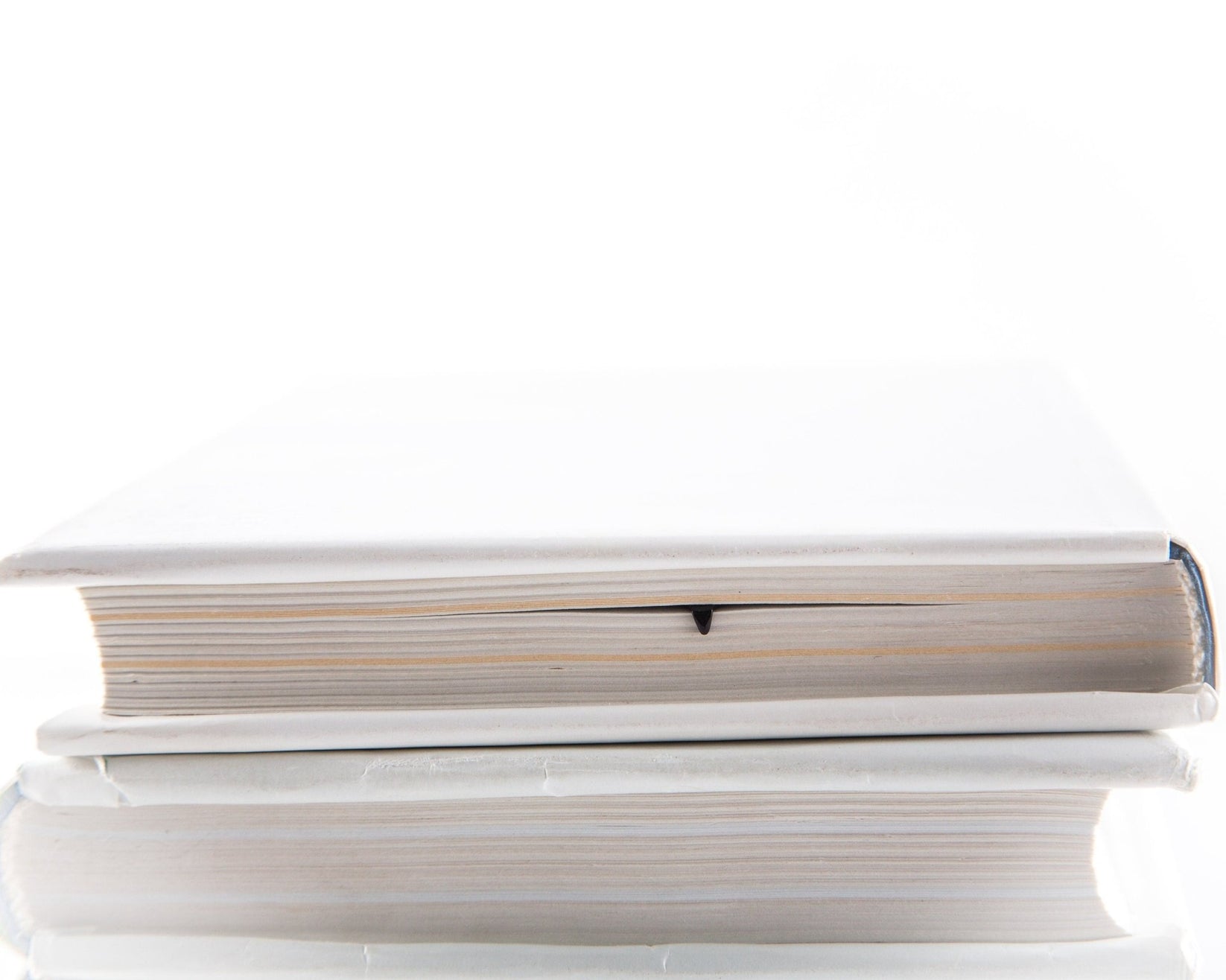 Pencil Read, Think, Create metal bookmark in a closed book, only its top showing above the pages