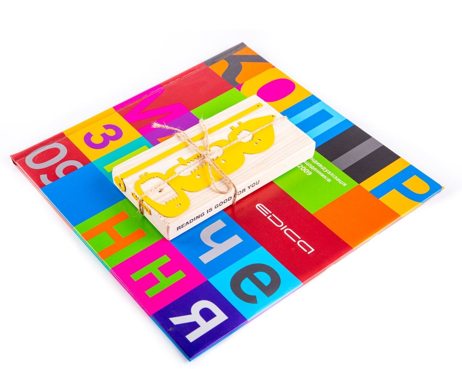 Three Screaming Monsters metal bookmark in gold against a coloured backdrop