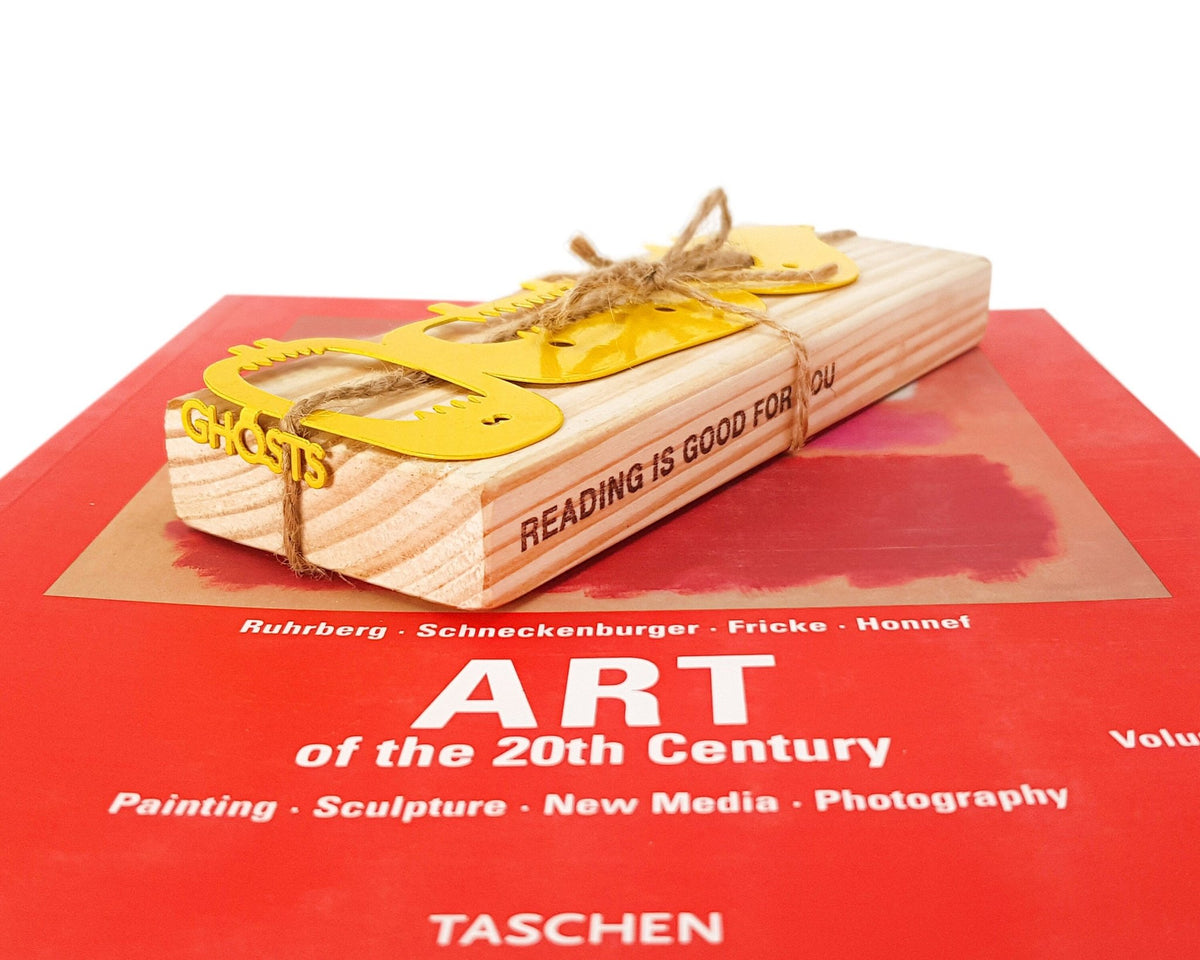Three Screaming Monsters metal bookmark in gold packed with kraft paper and twine as a gift