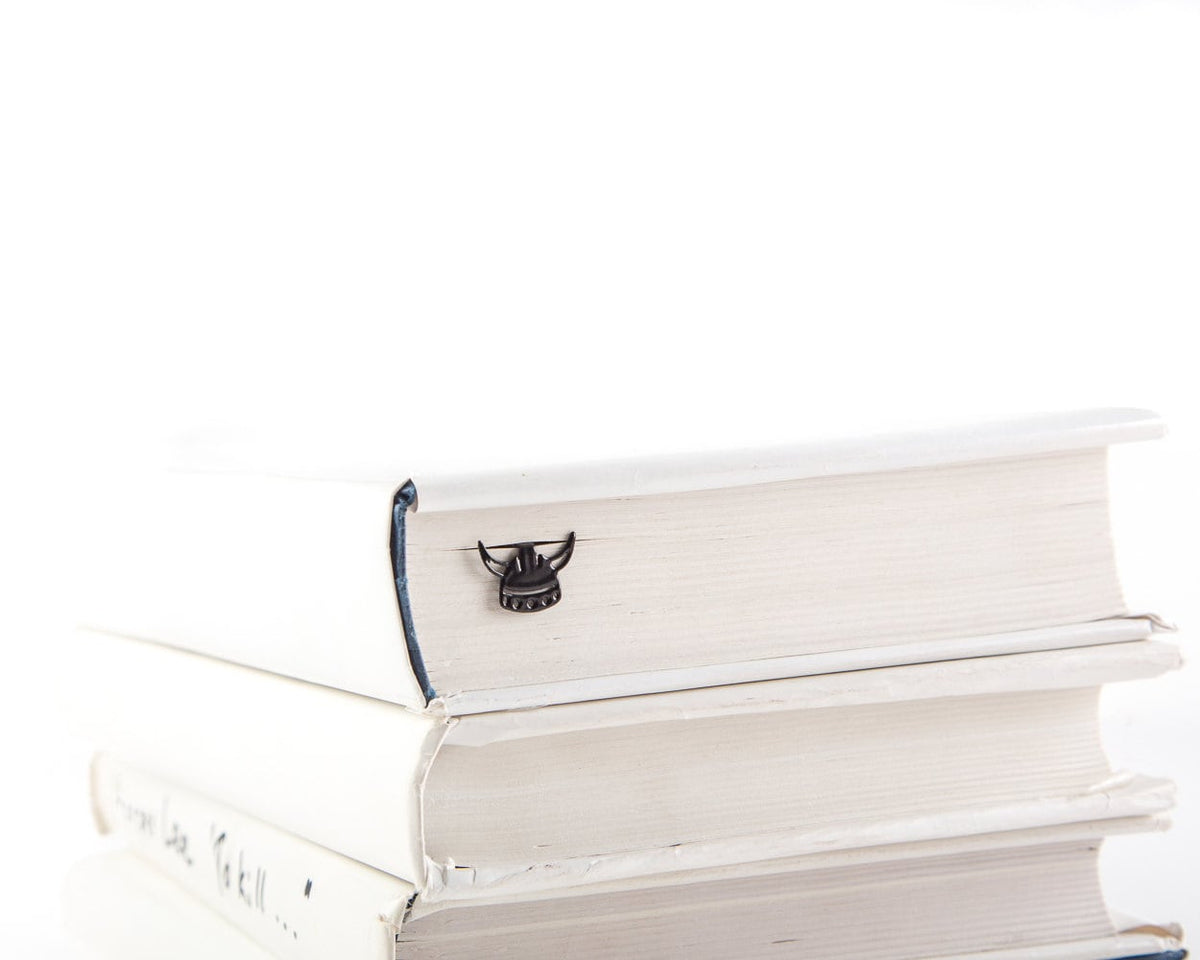 Viking Horned Helmet metal bookmark shown with a stack of books