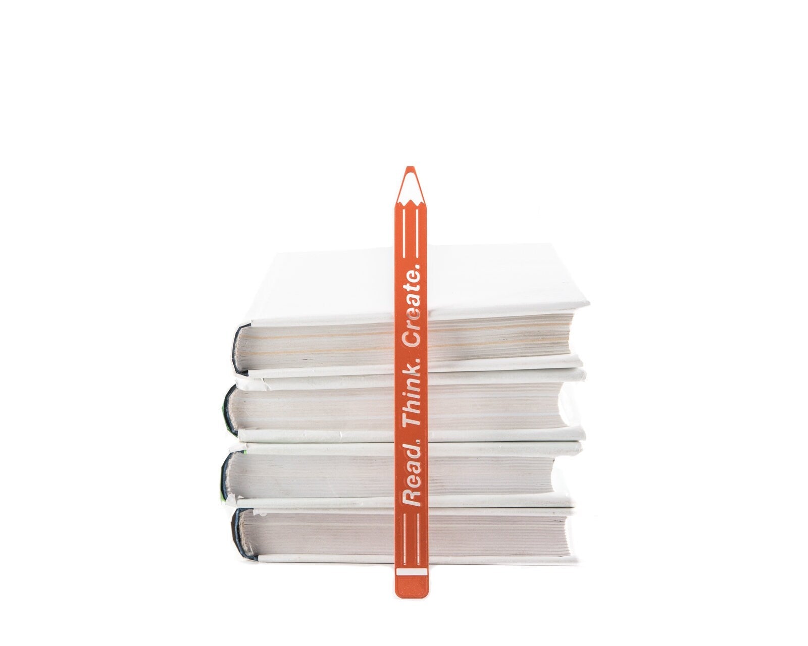 Read. Think. Create. Pencil metal bookmark in red shown with a stack of books