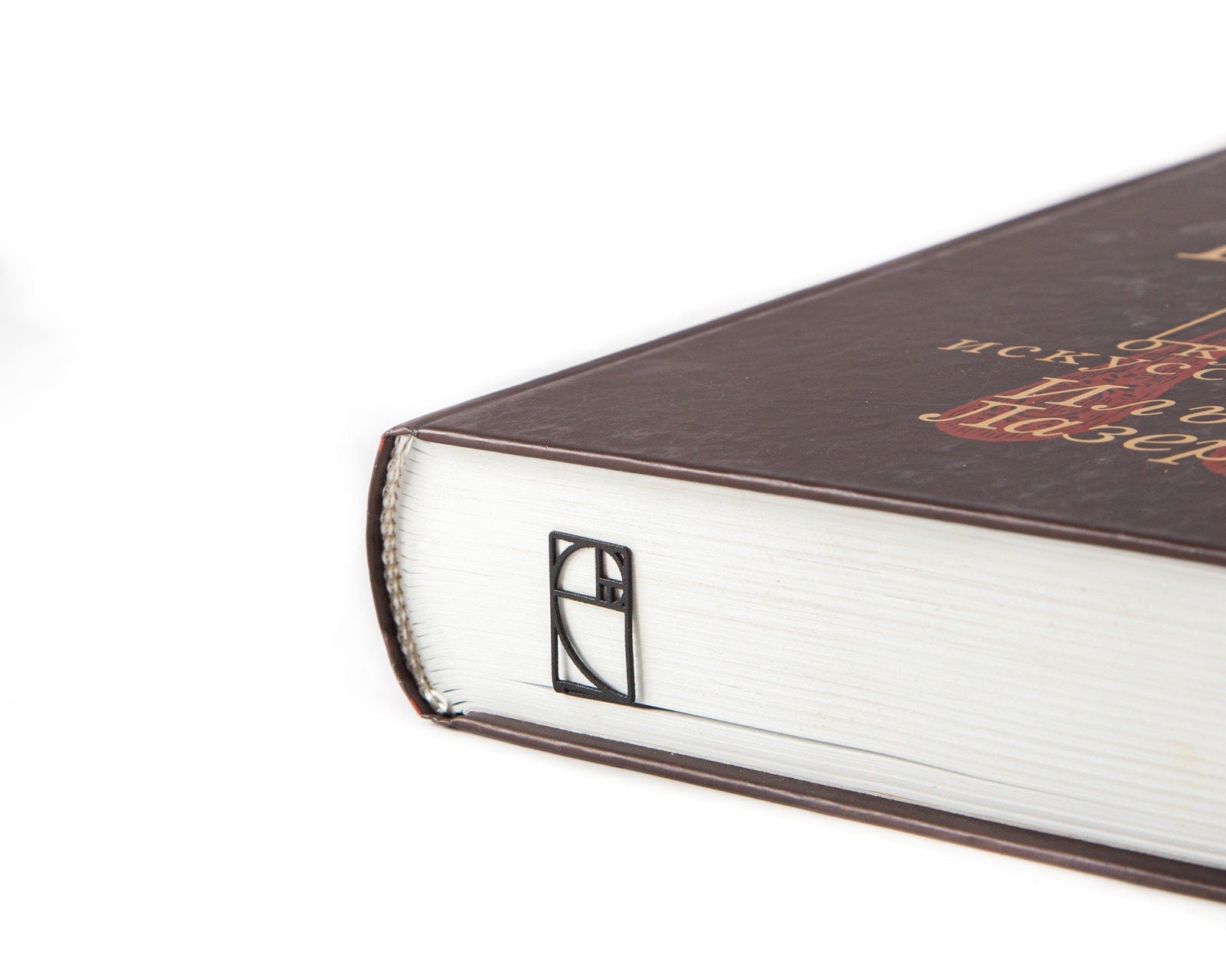 Golden Ratio metal bookmark seen from the edge of a closed book