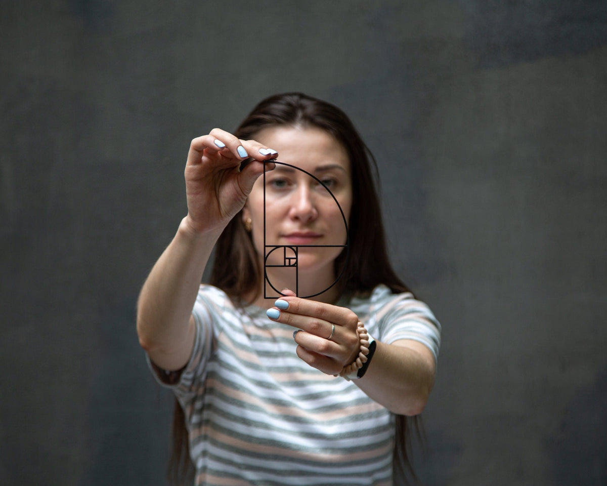 Golden Ratio metal bookmark — woman holds bookmark up to her eye