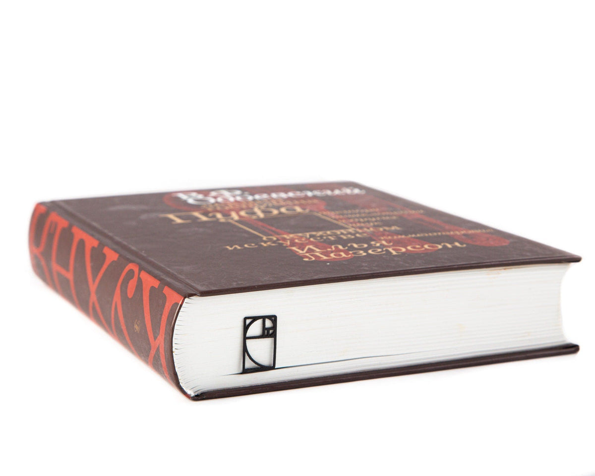 Golden Ratio metal bookmark in a closed book, only its top showing above the pages