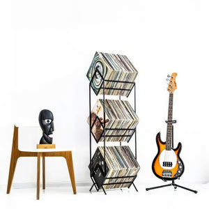 three-tier vinyl record stand by a guitar and a char with black head sculpture Division bell.