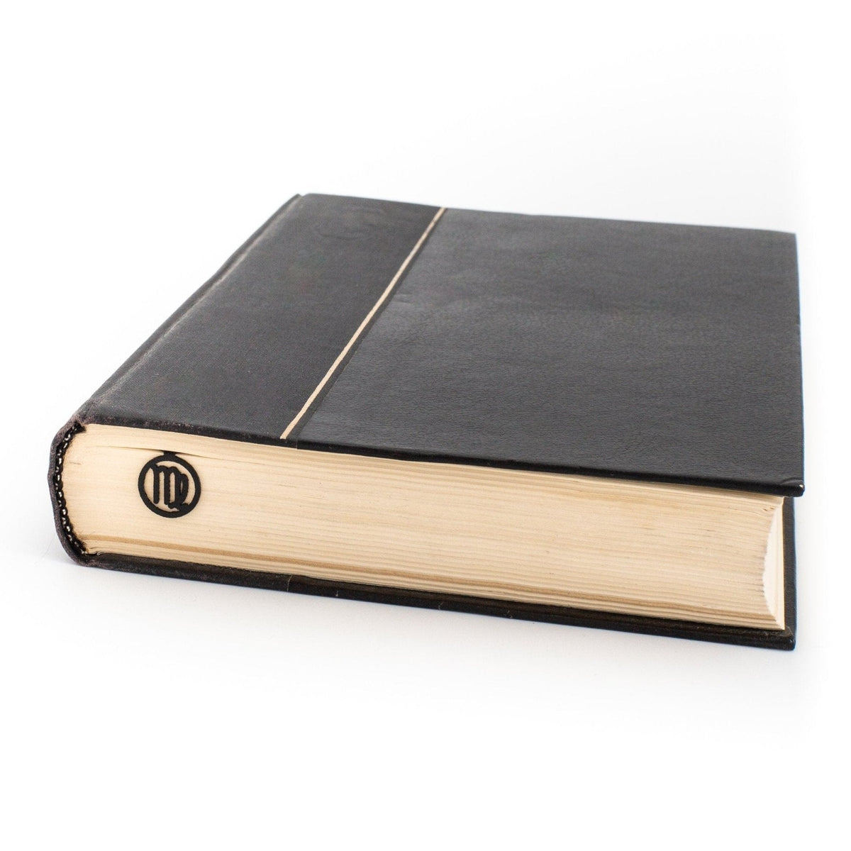 Virgo metal bookmark in a closed book, only its top showing above the pages