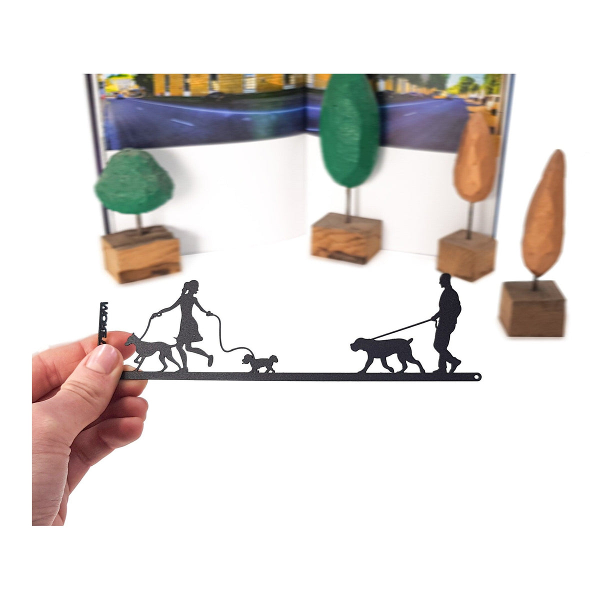 Walking the Dog metal bookmark held in a hand above an open book