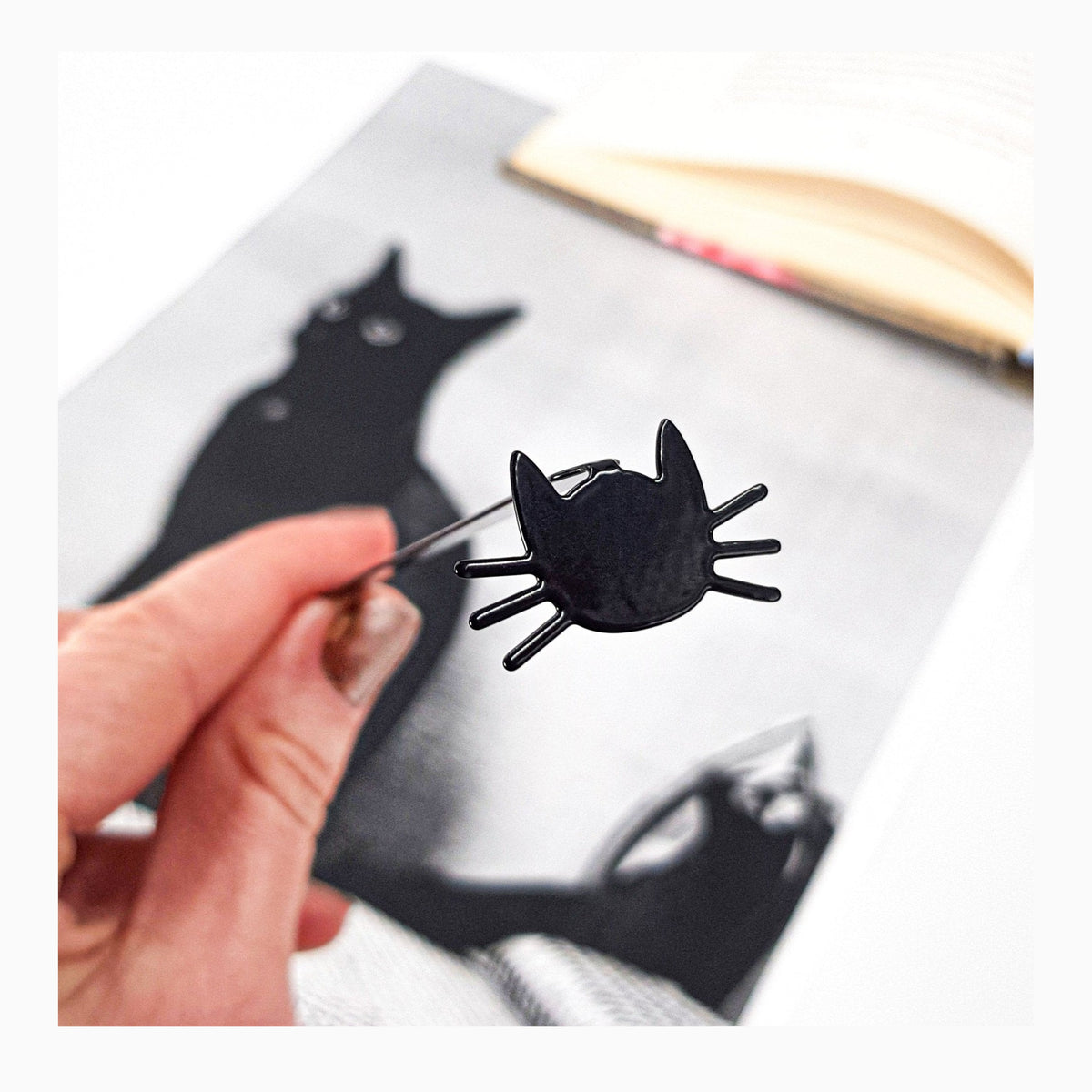 Whiskers in Your Book metal bookmark marking a page in an illustrated book
