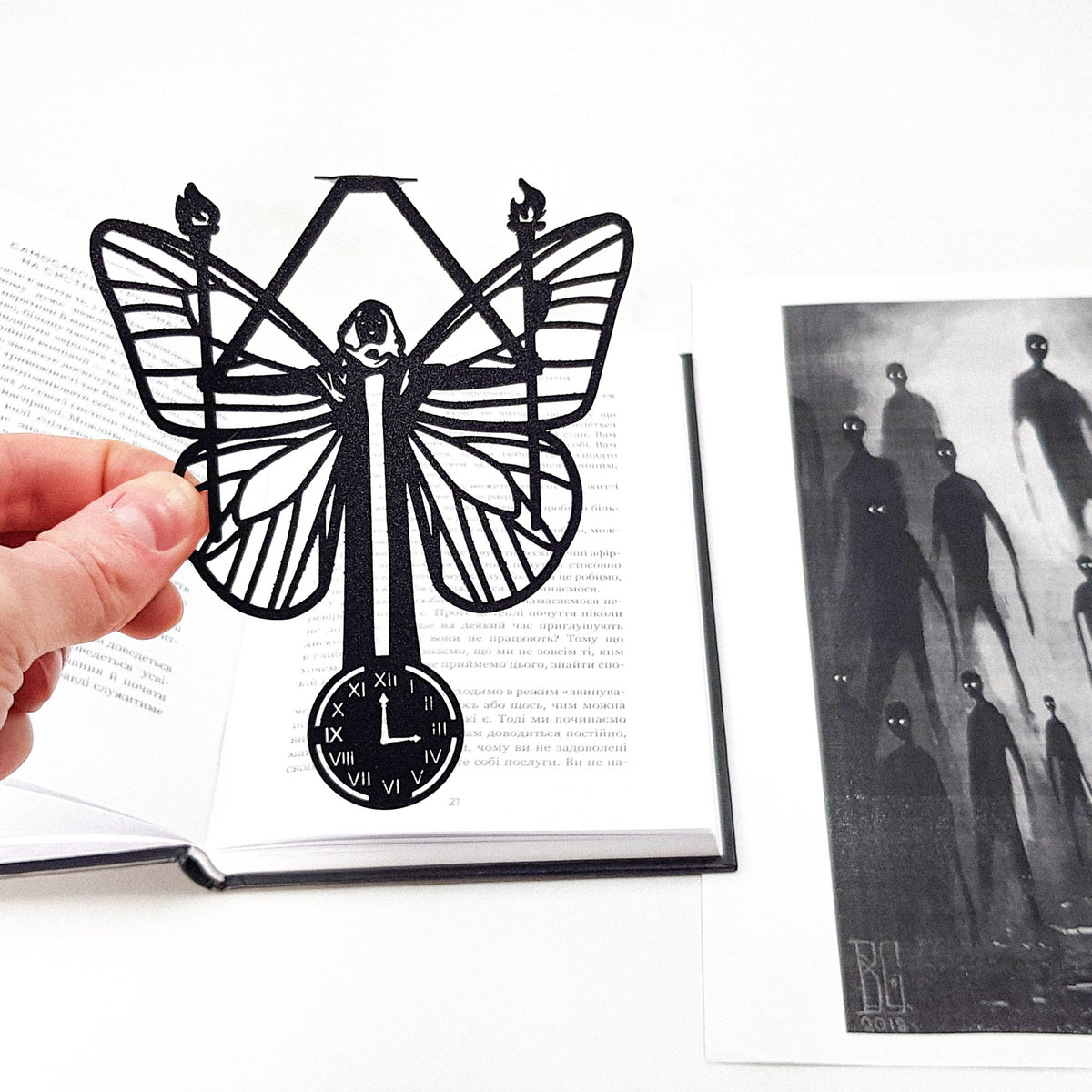Witch Hour metal bookmark held in a hand to show its size