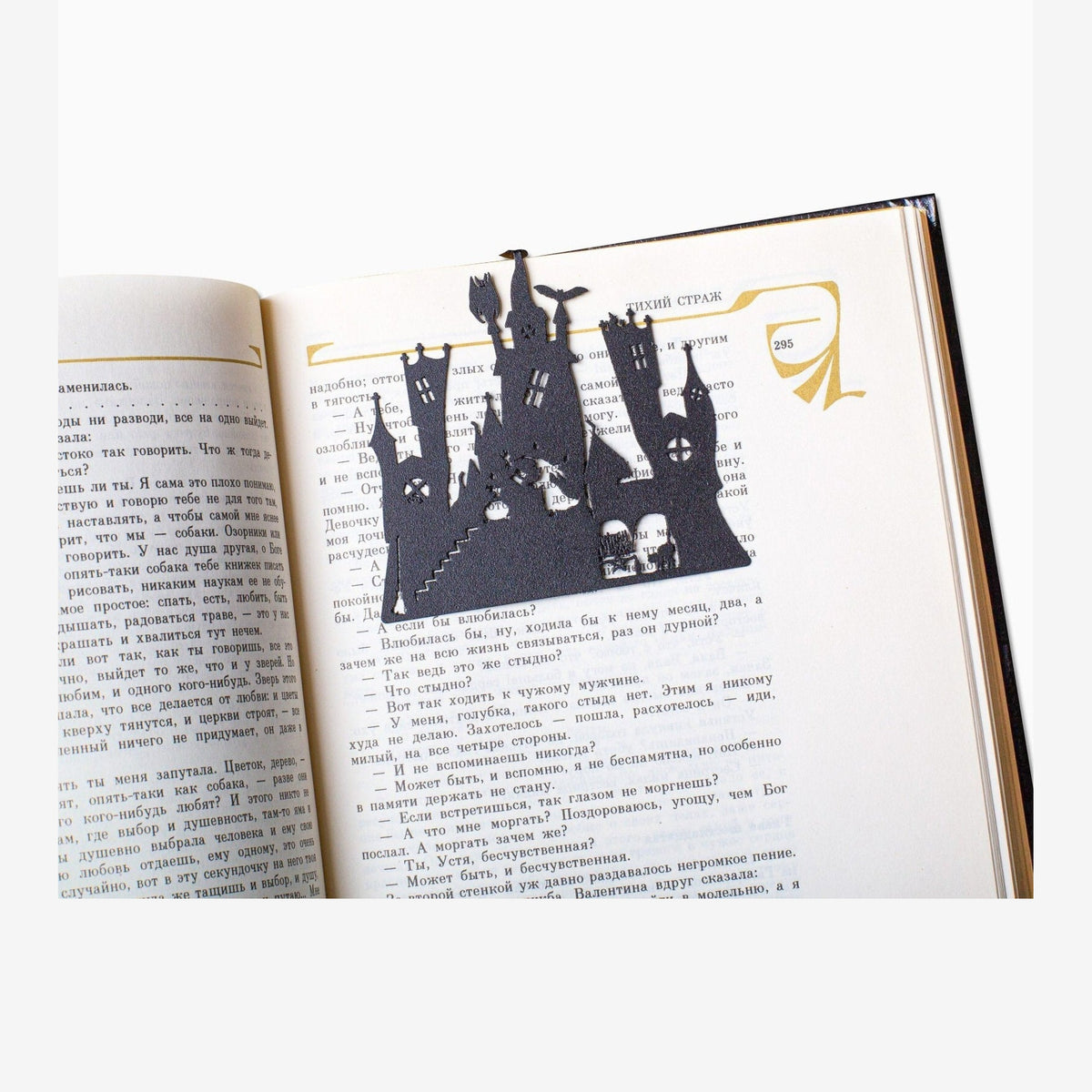 Witch's Castle metal bookmark resting on the pages of an open book