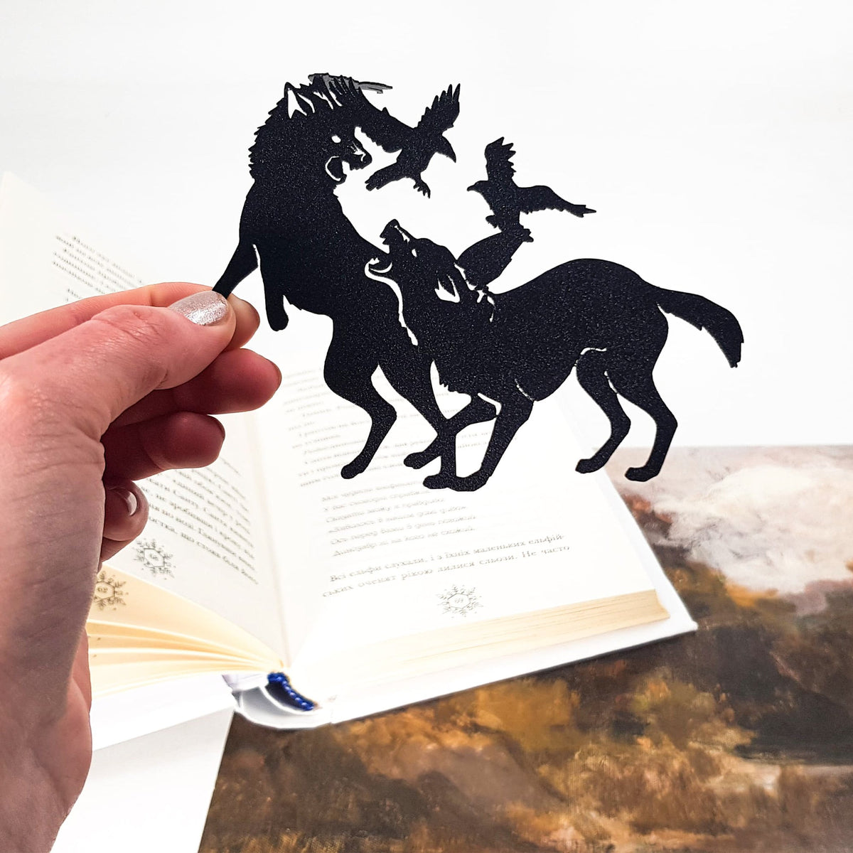 Wolves & Raven metal bookmark against a coloured backdrop