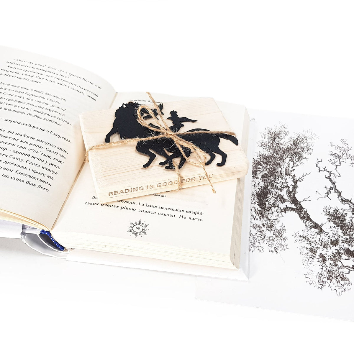 Wolves & Raven metal bookmark marking a page in an illustrated book