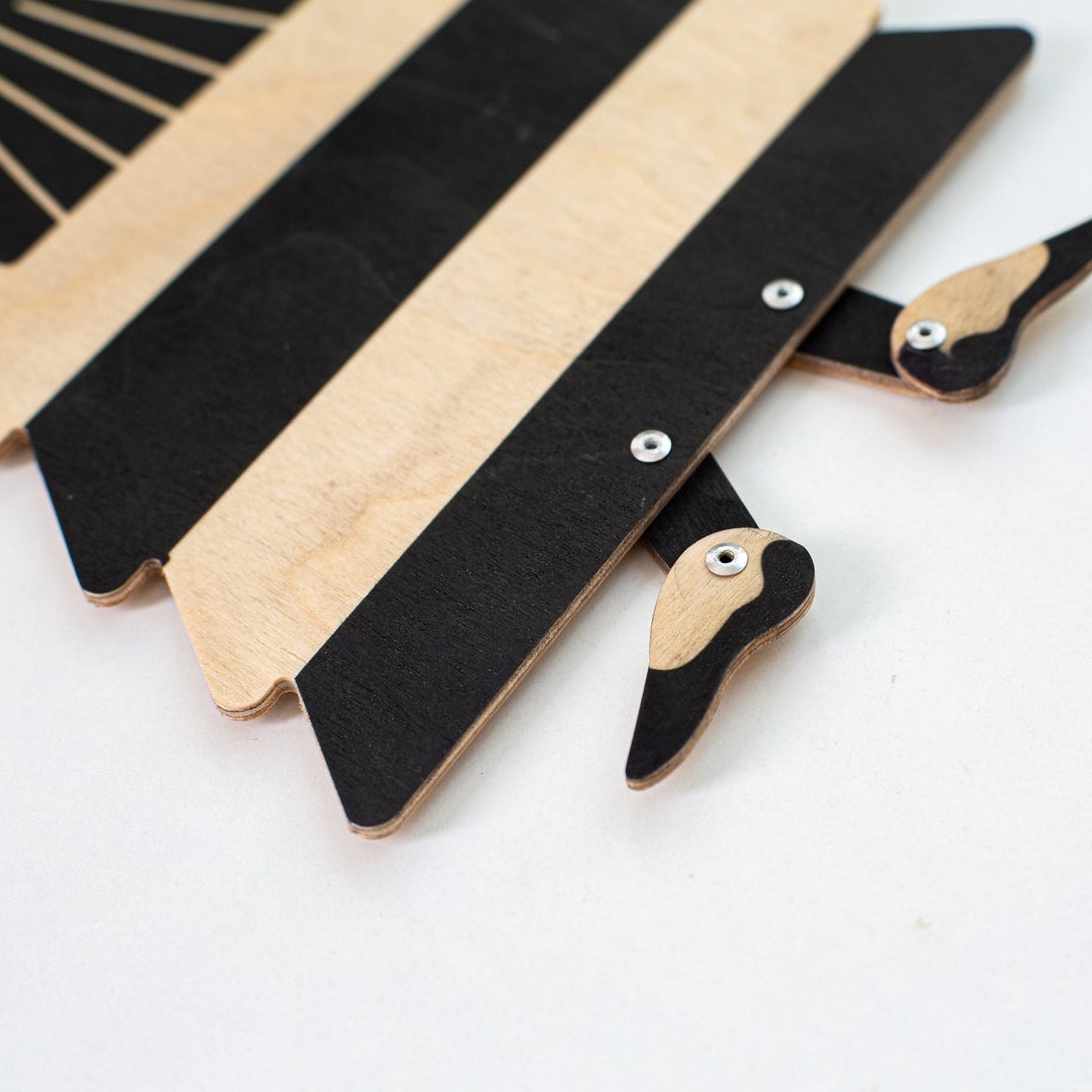 Detail of flamenco puppet skirt and feet — black print on natural plywood grain with metal rivets