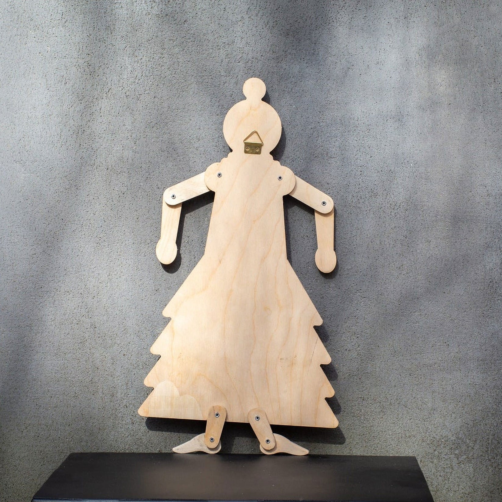 Back of wooden flamenco puppet showing natural plywood, brass wall hook and joint fasteners
