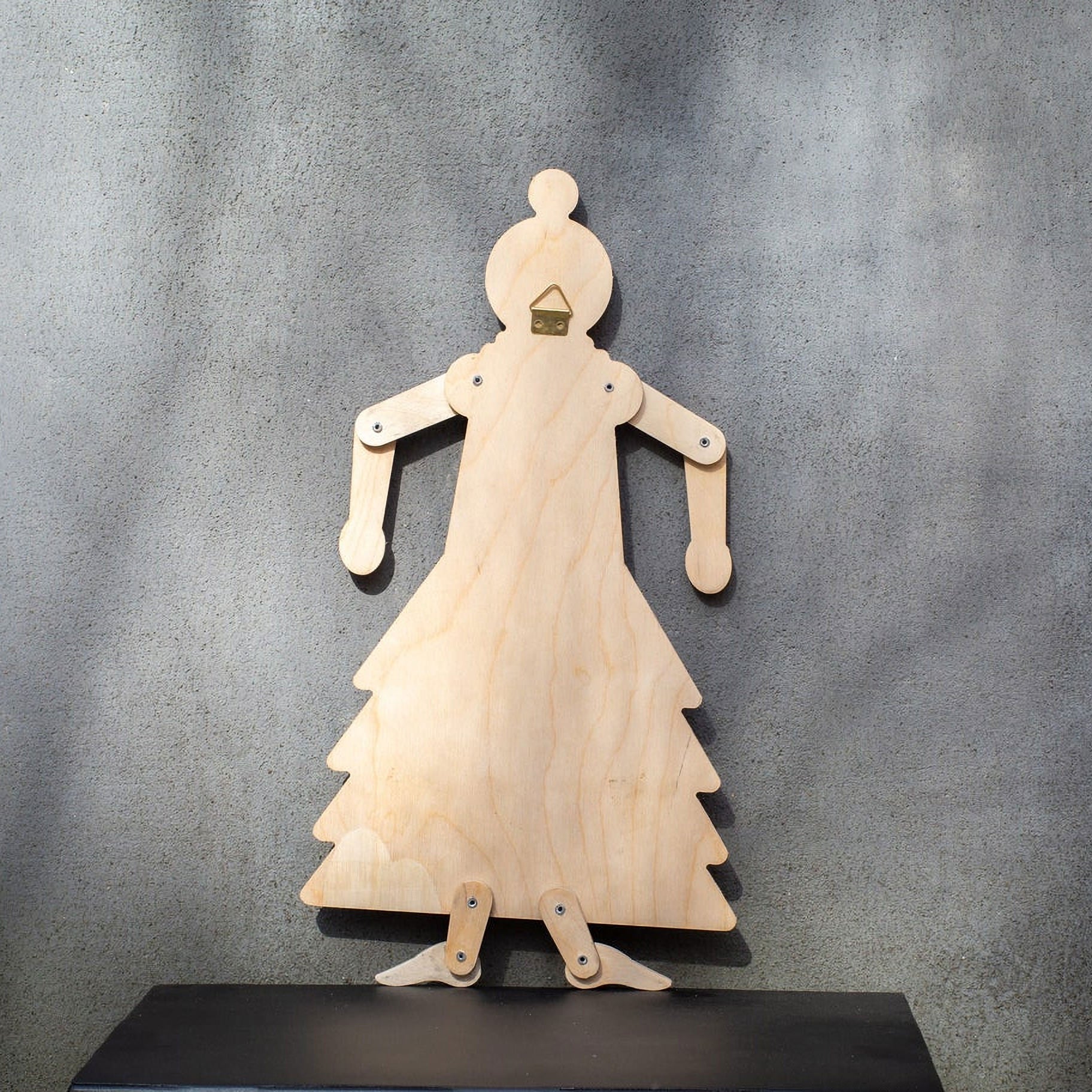 Back of wooden flamenco puppet showing natural plywood, brass wall hook and joint fasteners