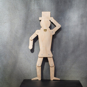 Back view of wooden gentleman puppet showing jointed construction and brass wall hook on grey background