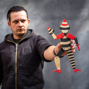 man holding handmade articulated plywood acrobat puppet showing size and movable joints