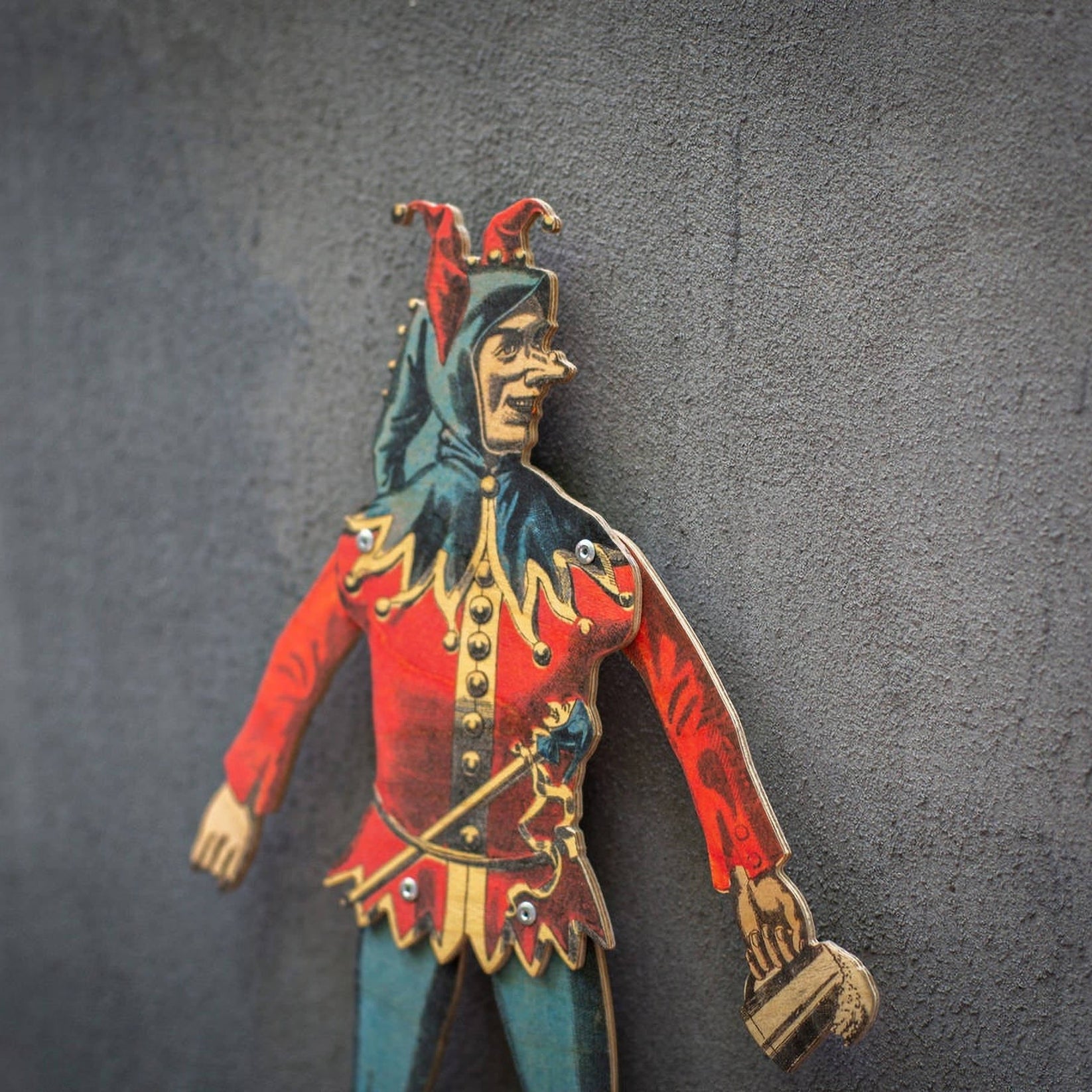 angled view of handmade articulated plywood jester puppet showing thickness and layered construction