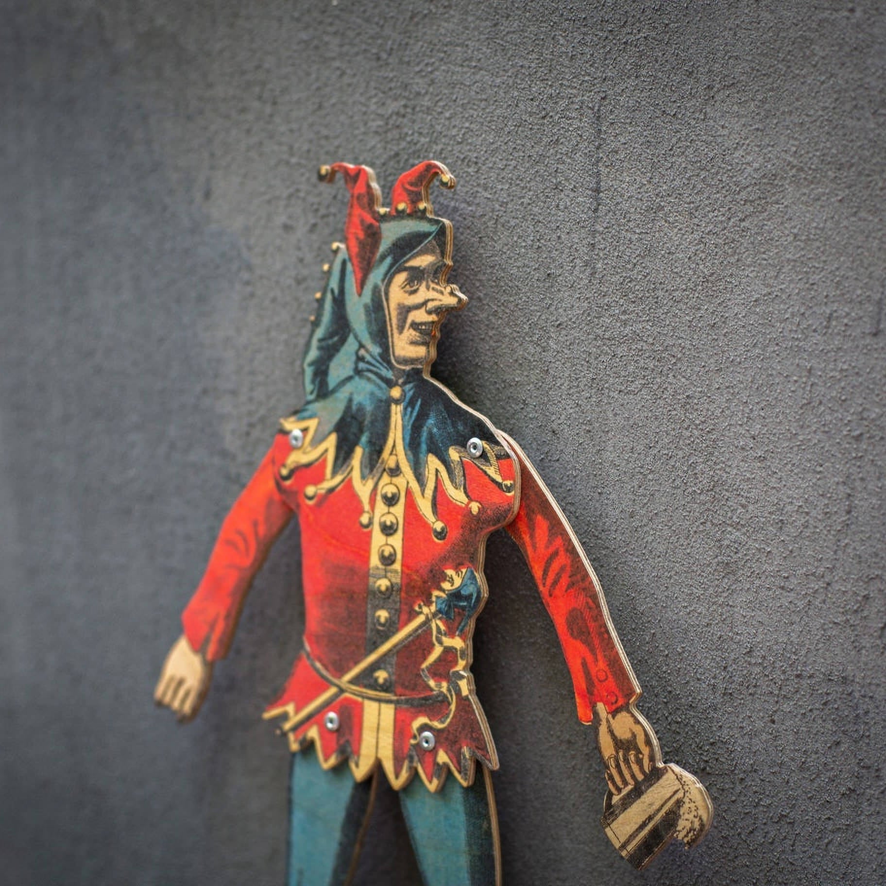 angled view of handmade articulated plywood jester puppet showing thickness and layered construction